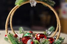 44 a cool Christmas decoration of two embroidery hoops, evergreens, red and silver ornaments and a bird on top is a lovely idea