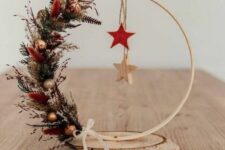 46 a stylish Christmas embroidery hoop decoration with greenery, dried grasses, small ornaments, a couple of wooden stars