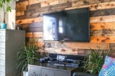 58 a weathered and stained wood accent wall softens the industrial-inspired living room with vintage touches