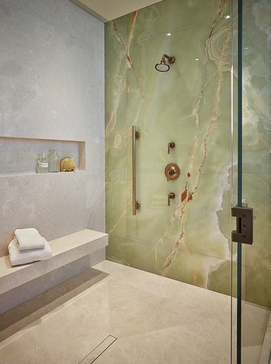 a fantastic shower space in neutrals accented with a green onxy statement wall that really wows