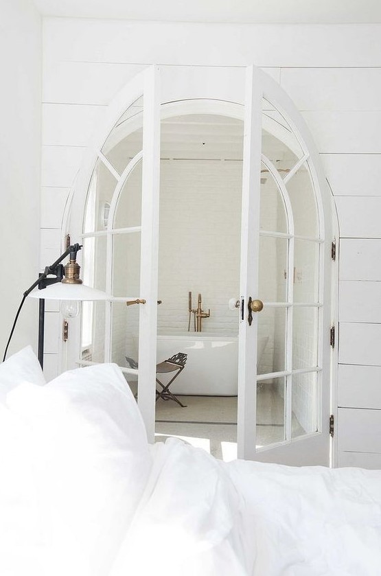 French arched doors leading to the bathroom make it more refined and chic at first glance