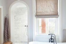 66 a contemporary bathroom with an arched doorway inviting to the shower space for more eye-catchiness