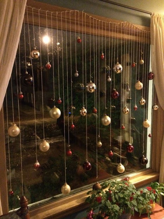 a Christmas ornament display on the window is a fantastic idea for the holidays, they are bold, cool and chic