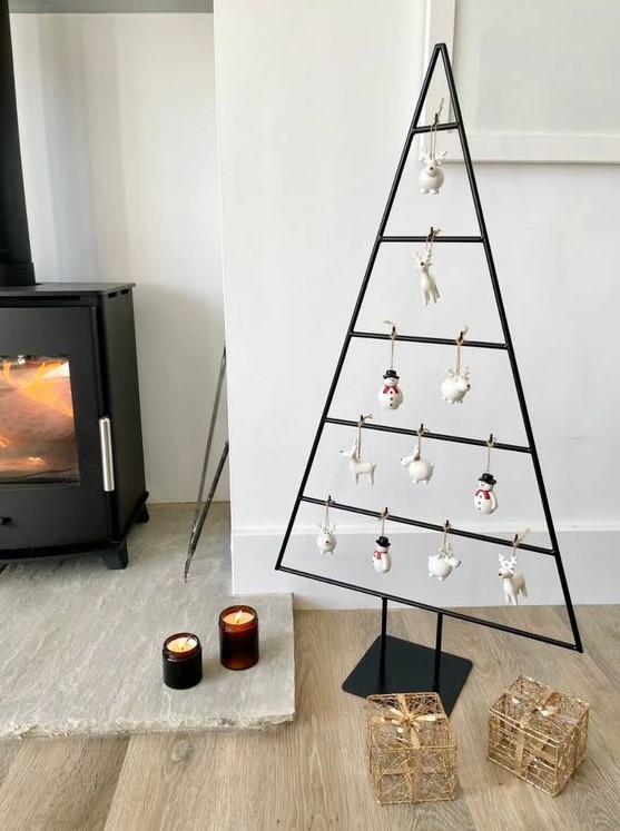 a black metal frame Christmas tree with animal and snowman-shaped ornaments for a touch of fun is a super cool idea
