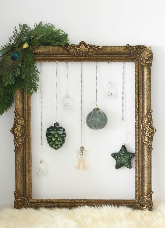 a chic Christmas wreath of a vintage frame, some evergreens, a peacock feather, hanging ornaments is a cool idea
