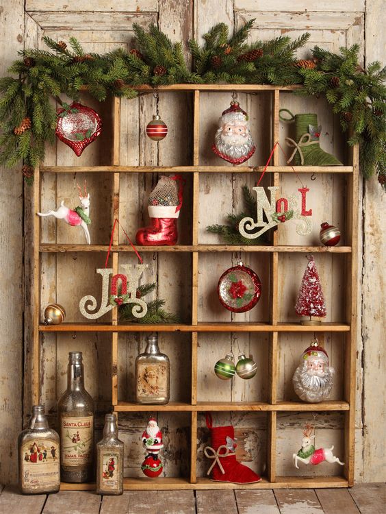 a creative vintage Christmas ornament stand with lots of vintage ornaments, evergreens and pinecones is adorable