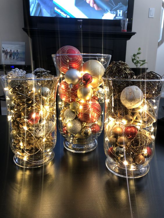 a dreamy Christmas display of large and tall glasses, pinecones, vine balls, Christmas ornaments and lights