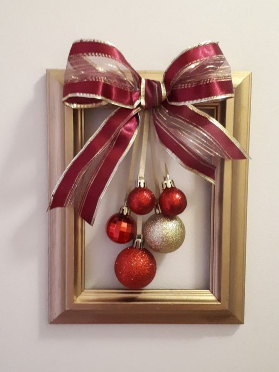 a frame Christmas wreath with red and gold ornaments and an oversized matching bow is a simple craft that looks cool