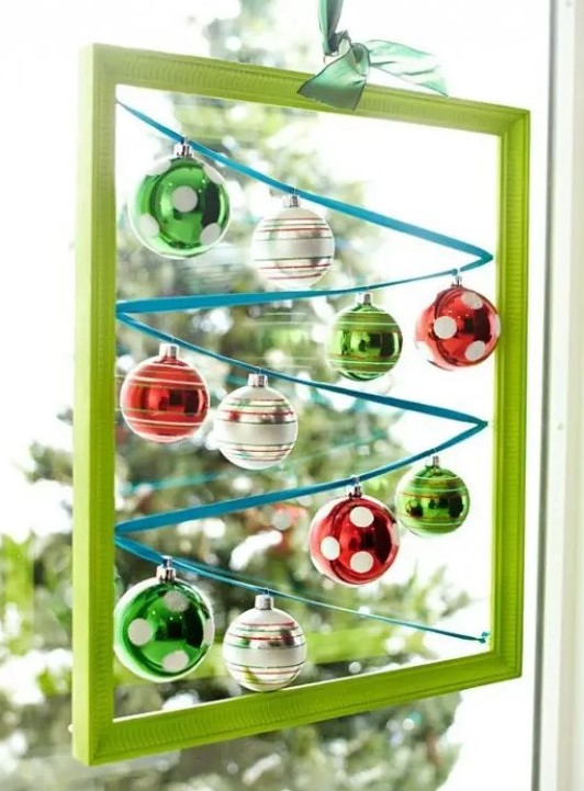 a green frame with colorful Christmas ornaments hanging inside is a cool and creative Christmas decorations
