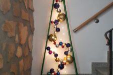 a green metal Christmas tree with lights and colorful ornaments plus a large lit up star on top is amazing for home decor