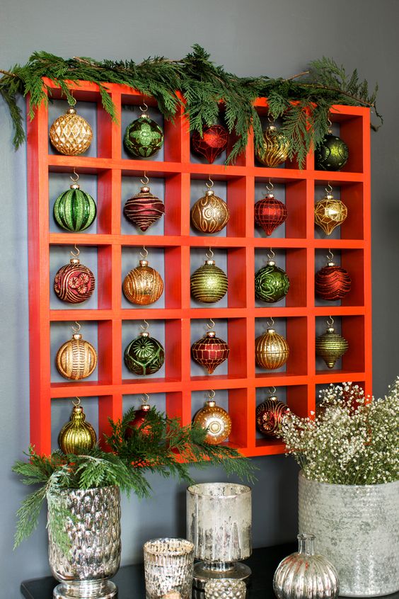 a large Christmas ornament display with lots of beautiful vintage ornaments and evergreens on top