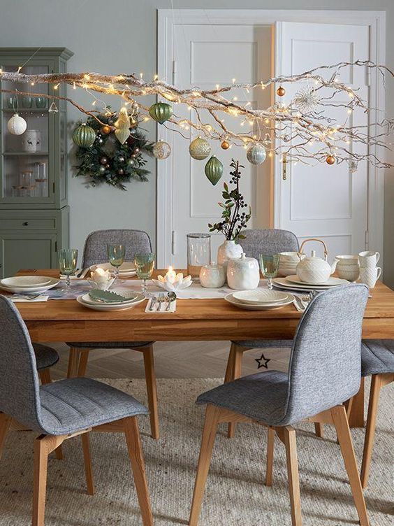 a large branch with white, gold and green ornaments and lights is a nice ornament display and a centerpiece alternative
