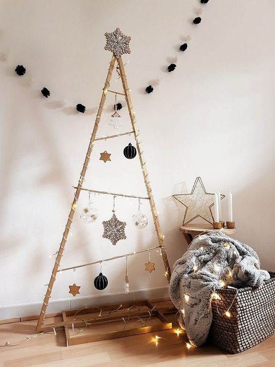 a large frame Christmas tree with lights, black, silver, clear and white ornaments and a large snowflake on top
