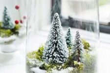 a large glass with moss and small bottle brush trees is a lovely idea of a snow globe with trees