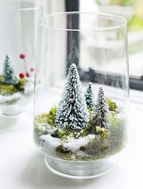 a large glass with moss and small bottle brush trees is a lovely idea of a snow globe with trees