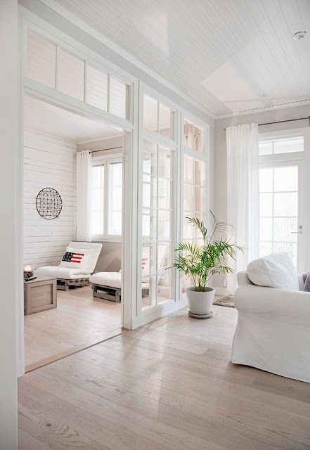 a light-filled white space with glazed walls, transom windows, vintage white furniture is a lovely and welcoming space