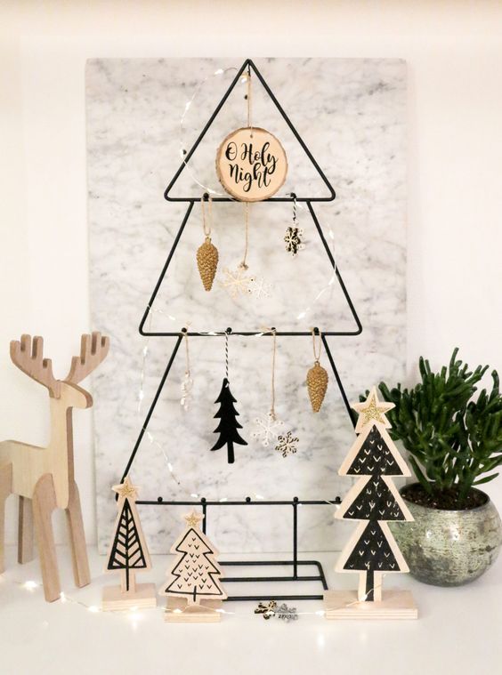 a metal frame Christmas tree with various wooden ornaments and a tree slice is a lovely idea for a Scandinavian space