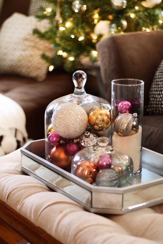 a mirror tray with cloches and a glass with vintage ornaments is a very elegant and chic Christmas decoration
