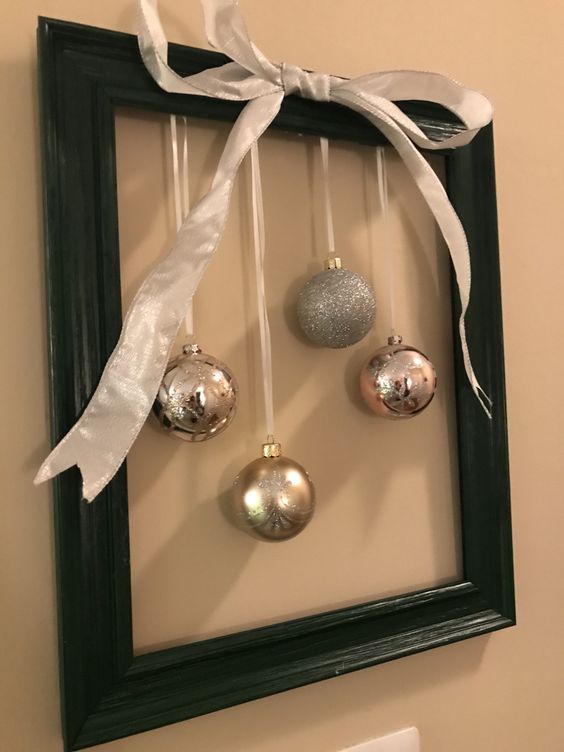 a modern frame Christmas wreath in black, with silver and silver glitter ornaments plus a silver bow on top is laconic and cool