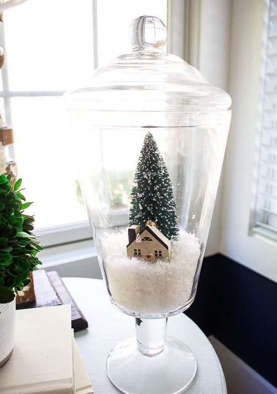 a pretty Christmas terrarium with faux snow, a cardboard house and a bottle brush tree is a lovely idea