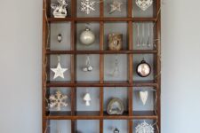 a pretty and simple Christmas ornament display with lights and various white and silver ornaments