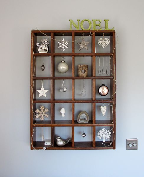 a pretty and simple Christmas ornament display with lights and various white and silver ornaments
