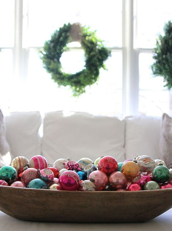 a primitive dough bowl filled with colorful vintage ornaments will be your perfect Christmas ornament display and decoration