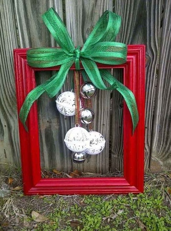 a red frame Christmas wreath with silver and white bells and a green bow is a lovely traditional decoration for the holidays