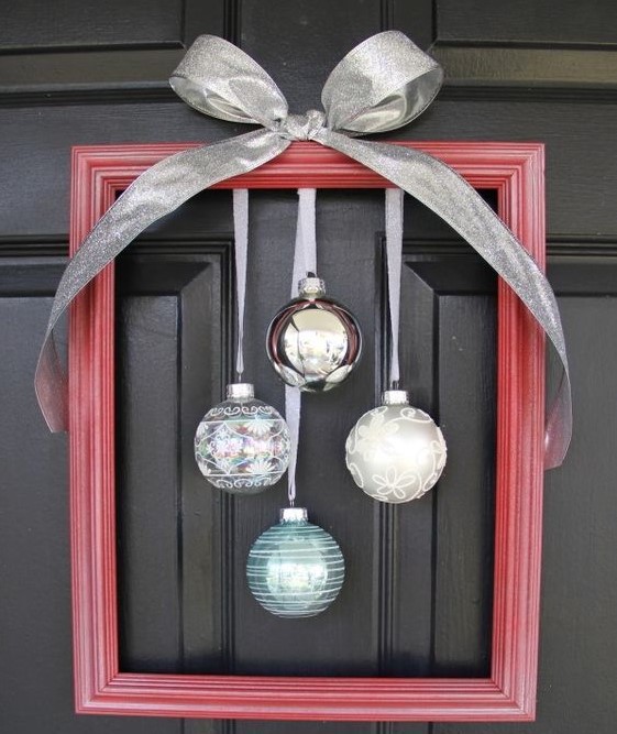a red frame Christmas wreath with silver, white and blue ornaments and a large bow on top is a gorgeous idea