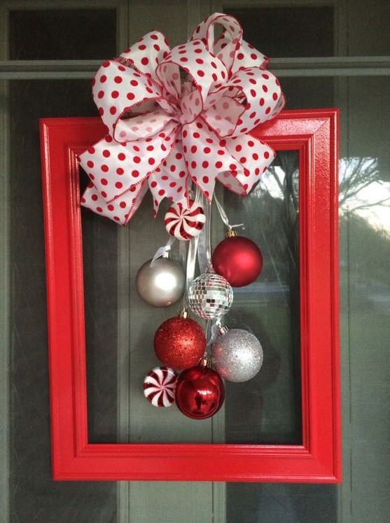 a red picture frame with silver, disco ball and candy Christmas ornaments and a polka dot bow on top is a lovely decor idea for the holidays