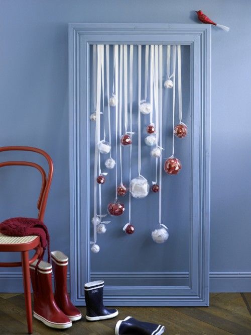 a simple frame with red and white ornaments hanging inside is a lovely idea for a holiday space