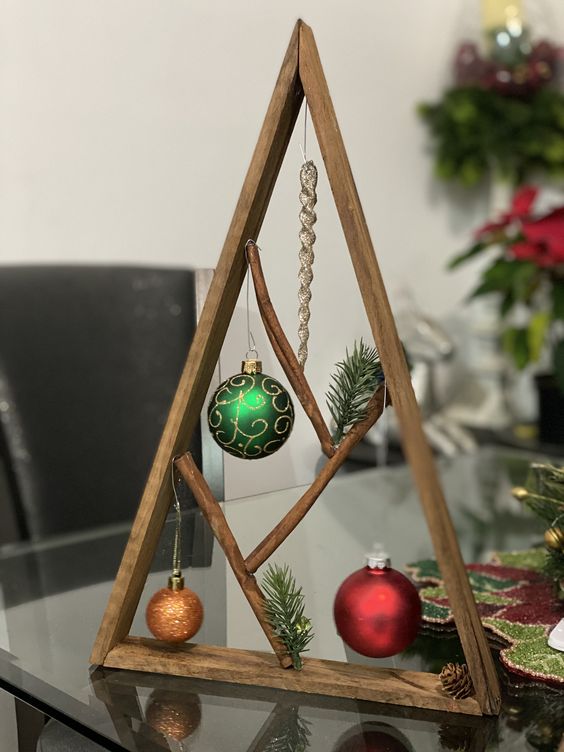 a small stained tabletop Christmas tree with evergreens, bold ornaments and a tiny pinecone is amazing for a woodland feel