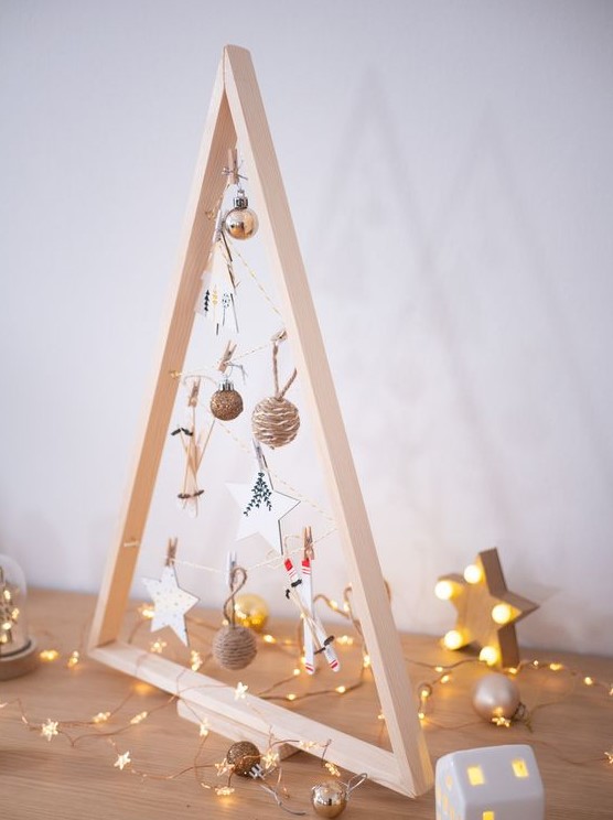 a small tabletop frame Christmas tree with yarn and clay star and ski ornaments is a cool and cute idea for the holidays