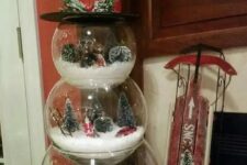 a snowman made of three glass terrariumsshowing some lovely and cozy winter scenes is a whimsy idea