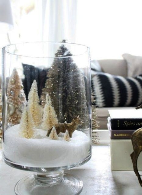 a tall glass Christmas terrarium with faux snow, neutral bottle brush trees and a fox is a cool idea that is easy to recreate