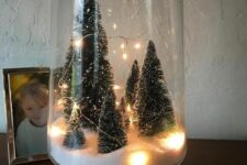 a tall glass terrarium with faux snow, some bottle brush trees and lights is easy to make yourself and looks cool