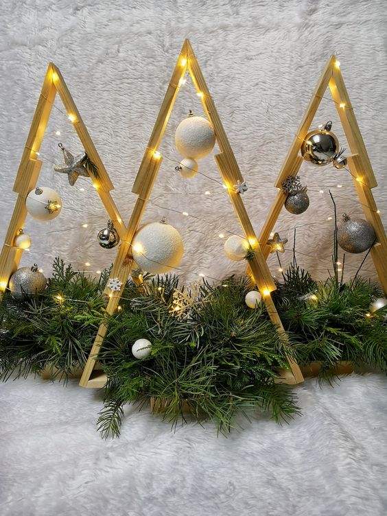 a trio of stained frame Christmas trees with white and silver ornaments and lights plus evergreens is amazing