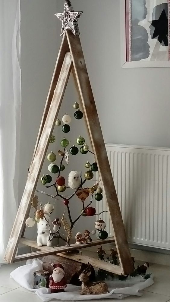 a woodland frame Christmas tree decorated with white, black, grene and gold ornaments, branches, a squirrel and an owl is fun