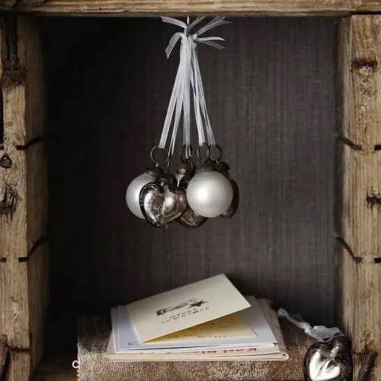 an arrangement of white and silver ornaments for Christmas is a chic and stylish idea to accent even a small nook