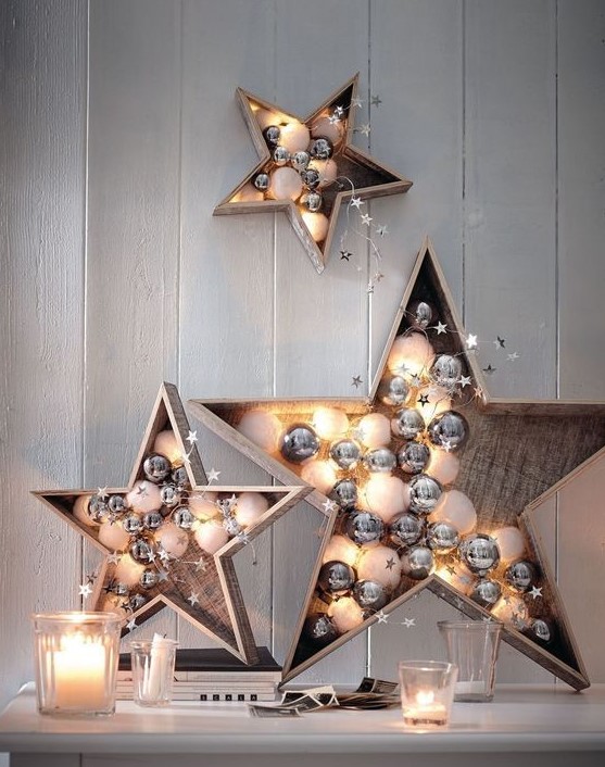 plywood stars filled with white and silver ornaments and lights are cute and chic festive decor options