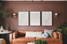 02 a beautiful and cozy living room with chocolate brown walls, an amber leather sofa, a tiered coffee table, potted greenery and artwork
