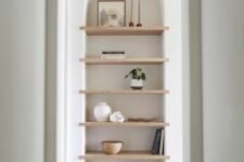 06 a large arched niche with wooden shelves for displaying stuff is a cool solution for an awkward nook