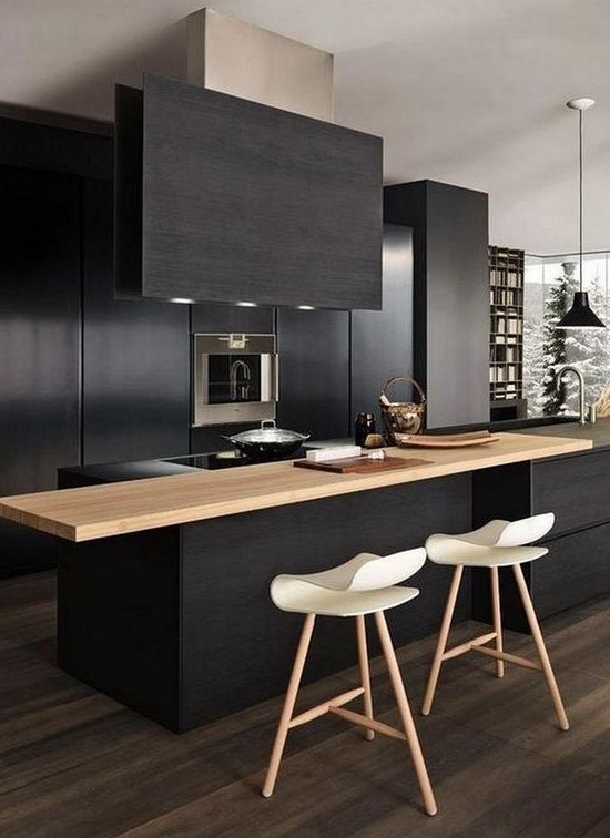 a contemporary black kitchen with sleek cabinets, built-in appliances, a light-colored wood countertop and a black hood