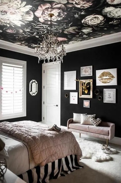 a glam black and blush bedroom with black walls, a moody floral ceiling, a gallery wall with gold and pink bedding