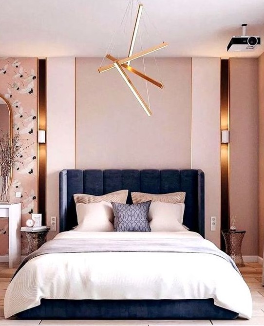 a modern luxurious bedroom with pink walls, catchy wallpaper, a navy bed, neutral bedding and touches of gold here and there