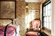 16 a vintage bedroom with floral wallpaper, a black forged bed, a vintage pink chair and printed textiles