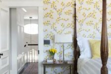 18 a vintage-inspired bedroom with yellow floral walls, a heavy bed with pillars, a chair and nightstands plus blooms