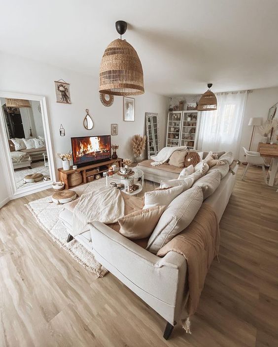 a welcoming neutral living room with a neutral corner sofa and lots of pillows, a rug, a coffee table, woven lamps