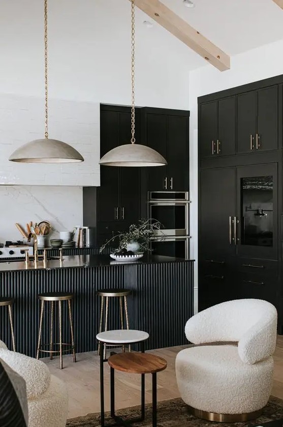 a sophisticated black and white kitchen with black and white cabinets, a black fluted kitchen island and gorgeous metal lamps hanging on chain