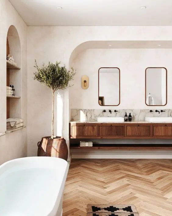 an arched niche with shelves is used for storing towels and bottles and it adds an architectural touch to the space